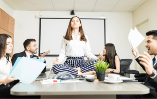 Young businesswoman meditating on a negotiating table while colleagues are yelling at each other in an office, NetSuite Starter